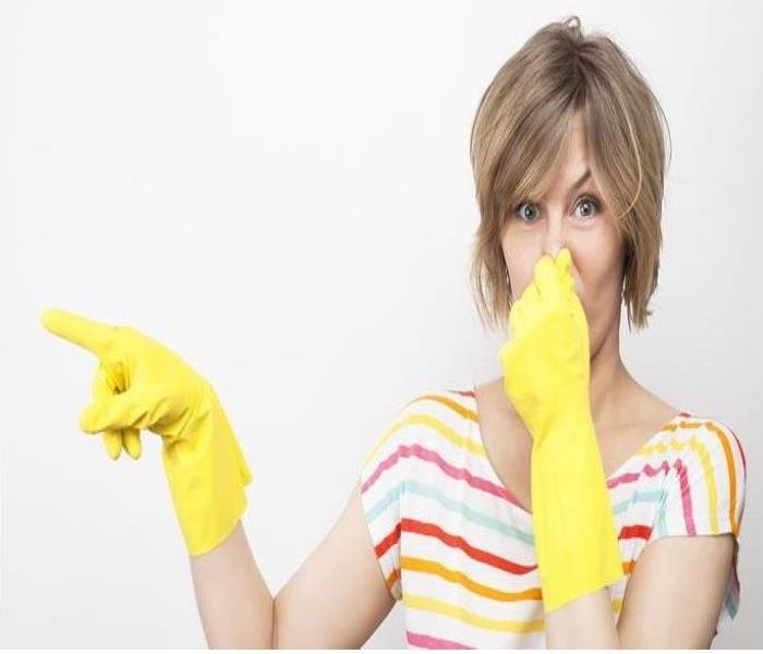 A woman covers her nose from an odor