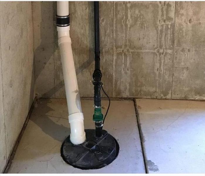 sump pump in the floor of a cement basement