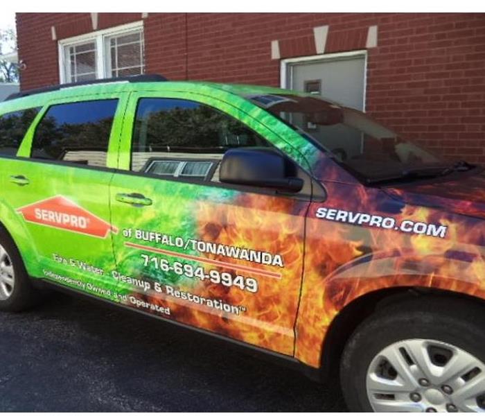 This is one of the SERVPRO vehicles which is green and orange with the SERVPRO franchise Name and Phone Number on the sides